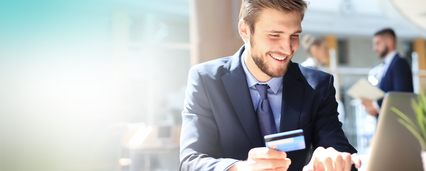 Деловен човек држи дебитна Mastercard Business картичка
